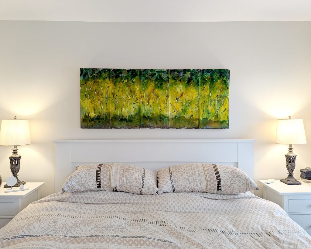 Mixed media painting hanging over bed